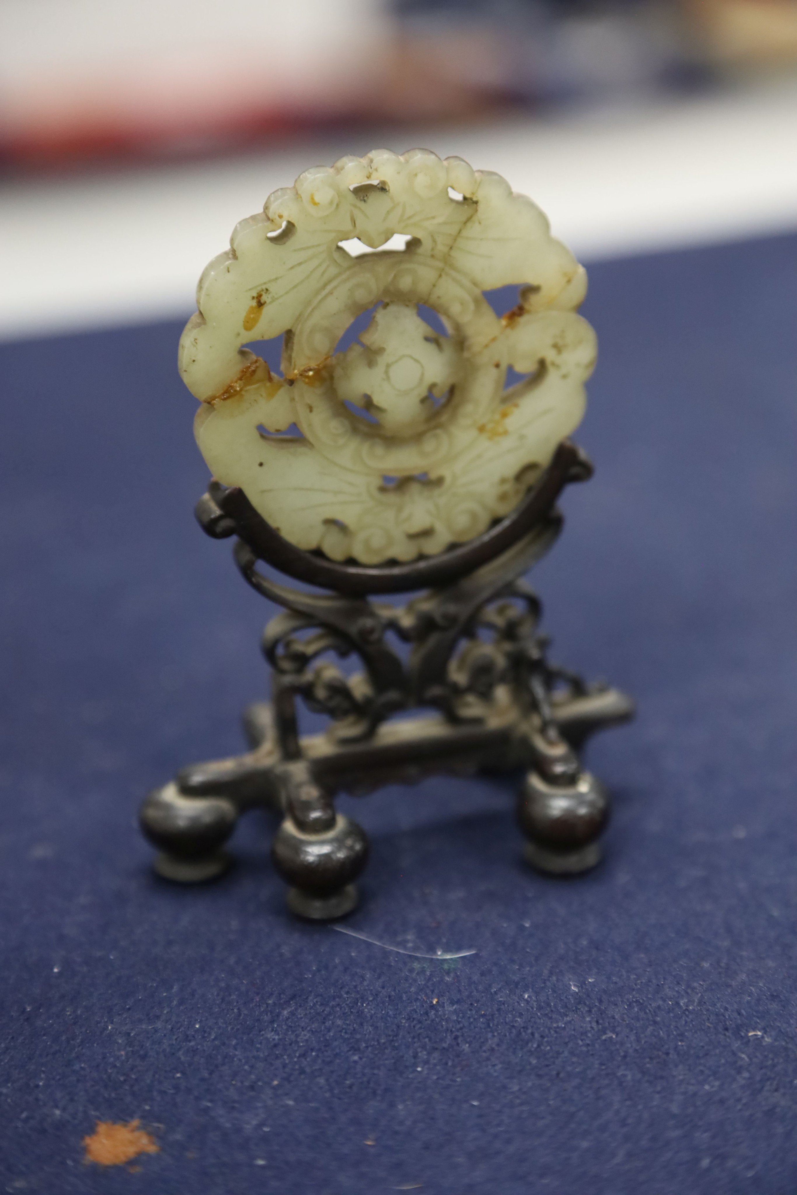 A Chinese small celadon jadeite lion on stand, a small jade circular plaque on stand (damage) and sundry items